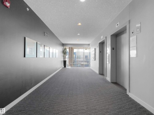Building hallway featuring dual elevators, recessed lighting, and a textured carpet runner - #415 2588 Anderson Wy Sw, Edmonton, AB 