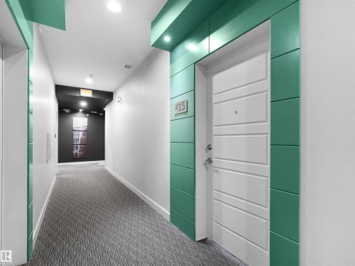 Hallway featuring recessed lighting, a patterned carpet runner, and decorative wall paneling - #415 2588 Anderson Wy Sw, Edmonton, AB 