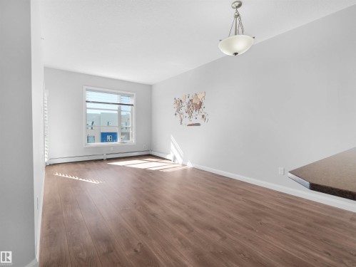 Wood-finish flooring, white walls, and a single window with horizontal blinds - #415 2588 Anderson Wy Sw, Edmonton, AB 