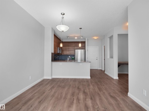 Wood-finish flooring, recessed lighting, built-in desk, stainless steel appliances, and a kitchen island - #415 2588 Anderson Wy Sw, Edmonton, AB 