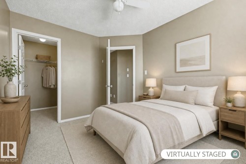 Neutral interior space featuring carpeted flooring, a walk-in closet with integrated shelving, and a ceiling-mounted fan - 9047 Scott Crescent Nw, Edmonton, AB 