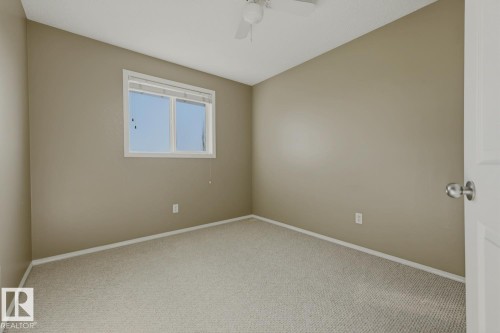 Room featuring neutral-toned walls, carpeting, and a ceiling fan with integrated lighting - 9047 Scott Crescent Nw, Edmonton, AB 