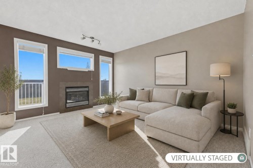 Living area featuring a tile-surround fireplace, three multi-pane windows, and recessed ceiling track lighting - 9047 Scott Crescent Nw, Edmonton, AB 