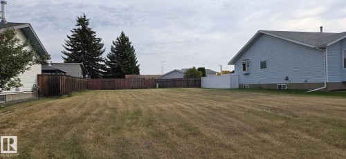 Expansive lot with partial wood fencing and partial white vinyl fencing - 5613 45A Street, Vegreville, AB 