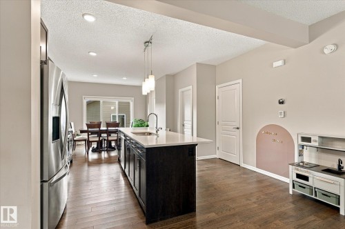Hardwood-finish flooring, recessed lighting, and a kitchen island with pendant lighting and an undermount sink - 21935 91 Avenue Nw, Edmonton, AB 