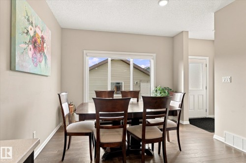Wood-finish flooring, neutral wall paint, and a sliding glass patio door - 21935 91 Avenue Nw, Edmonton, AB 