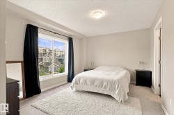 Wall-to-wall carpeting and a large window with black drapery - 