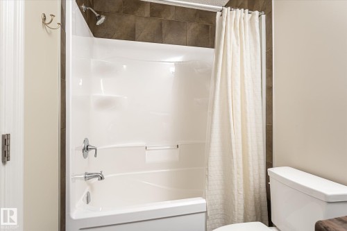 Tub and shower combination with chrome fixtures and tile surround - 21935 91 Avenue Nw, Edmonton, AB 