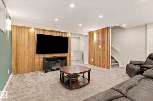 Wood-slat accent wall, recessed ceiling lighting, wall-mounted light fixtures, carpeted flooring, and built-in media console - 21935 91 Avenue Nw, Edmonton, AB 