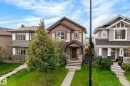 Two-story brown and tan exterior with stone accents, a covered front entry, and a concrete walkway - 21935 91 Avenue Nw, Edmonton, AB 