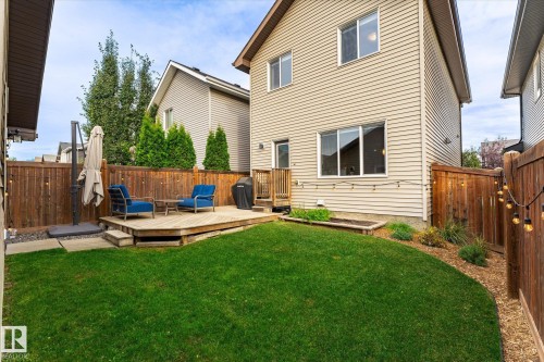 Expansive backyard featuring a manicured lawn, a wooden deck, and full privacy fencing - 21935 91 Avenue Nw, Edmonton, AB 