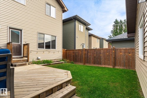 Expansive wooden deck with steps, leading to a vibrant green lawn - 21935 91 Avenue Nw, Edmonton, AB 