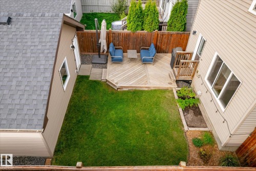 Expansive backyard featuring a manicured lawn, multi-level wood deck, and wood privacy fencing - 21935 91 Avenue Nw, Edmonton, AB 