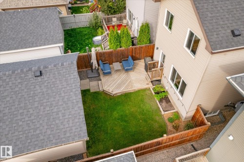 Expansive backyard featuring a manicured lawn, wood fencing, a multi-level wood deck, and a raised garden bed - 21935 91 Avenue Nw, Edmonton, AB 