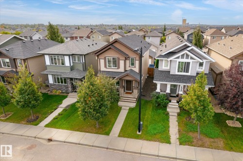 Contemporary two-story residence with a covered front porch, stone and siding exterior, and landscaped front yard - 21935 91 Avenue Nw, Edmonton, AB 