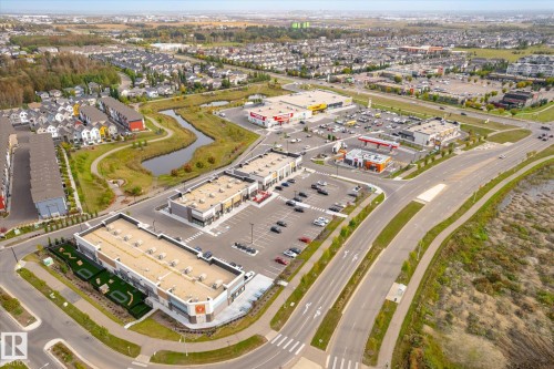 Mixed-use development featuring commercial retail spaces, surface parking, and residential townhomes - 21935 91 Avenue Nw, Edmonton, AB 