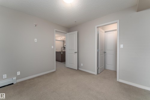 Neutral-toned interior featuring carpet flooring and light gray walls - #202 105 Ambleside Dr Sw, Edmonton, AB 