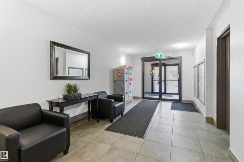Tiled flooring, double glass entry doors, white painted walls, and built-in mailboxes - #403 105 Ambleside Dr Sw, Edmonton, AB 