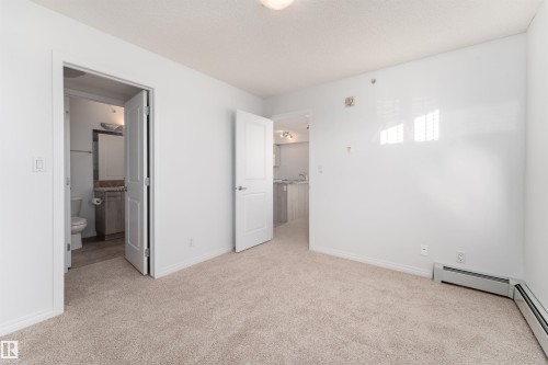 Neutral tone wall finishes, light-toned carpeting, and white interior doors - #403 105 Ambleside Dr Sw, Edmonton, AB 