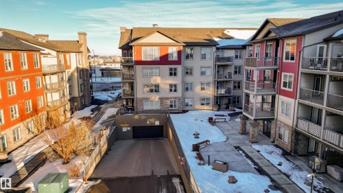 Multi-story building featuring balconies, stone accents, and a subterranean parking entrance - #403 105 Ambleside Dr Sw, Edmonton, AB 