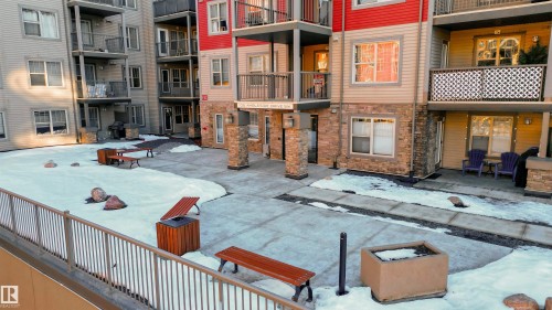 Central courtyard with stone pillars, concrete walkways, and communal seating - #403 105 Ambleside Dr Sw, Edmonton, AB 