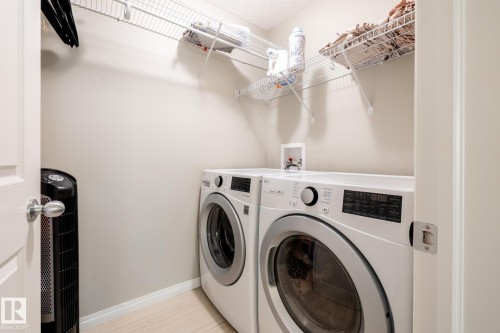 Laundry closet featuring wall-mounted wire shelving and dedicated water hookups - 2093 Chalmers Way Sw, Edmonton, AB 