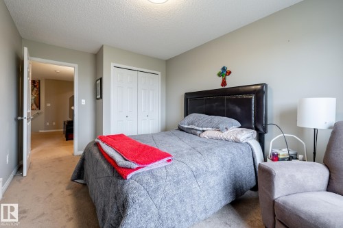 Neutral-toned interior featuring wall-to-wall carpeting and a double-door reach-in closet - 2093 Chalmers Way Sw, Edmonton, AB 