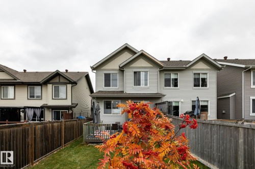Two-story residence featuring horizontal lap siding, a gabled roofline, private wood fencing, and an elevated rear deck - 2093 Chalmers Way Sw, Edmonton, AB 