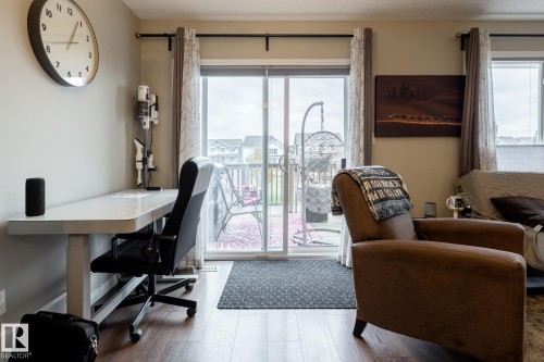Sliding glass door with horizontal blinds and wood-finish flooring - 2093 Chalmers Way Sw, Edmonton, AB 