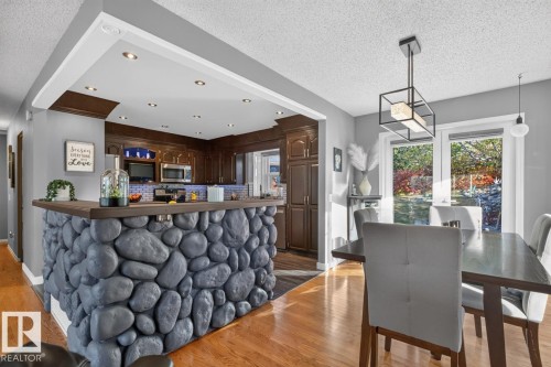 Kitchen features wood cabinetry, stainless steel appliances, and recessed lighting - 5502 48 Avenue, Beaumont, AB 