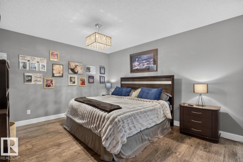 Wood-finish flooring, recessed lighting, and a crystal chandelier - 5502 48 Avenue, Beaumont, AB 