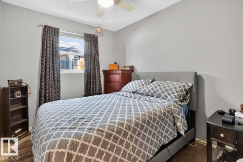 Window with roller blinds, ceiling fan with light fixture, wood-finish flooring, painted walls - 5502 48 Avenue, Beaumont, AB 