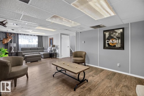 Wood-finish flooring with a neutral gray wall finish, recessed lighting, and a drop ceiling - 5502 48 Avenue, Beaumont, AB 