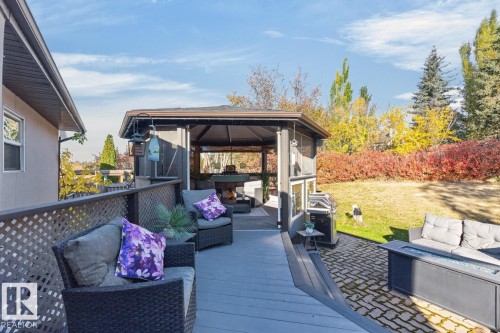 Expansive deck with lattice railing, a screened gazebo, and a paved patio area - 5502 48 Avenue, Beaumont, AB 