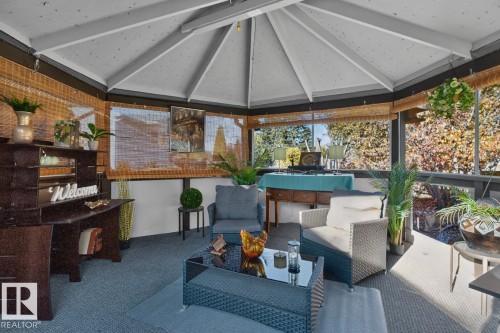Screened-in porch featuring a vaulted ceiling with exposed beams, wood-finish blinds, and ample natural light - 5502 48 Avenue, Beaumont, AB 