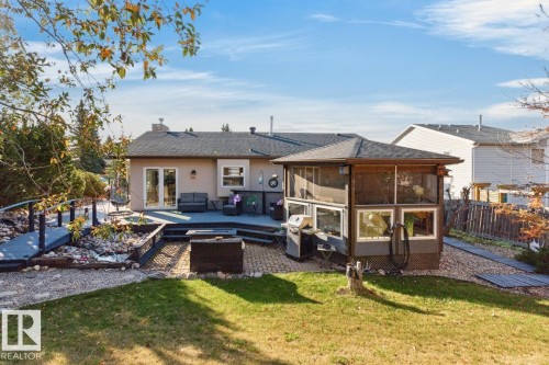 Expansive backyard featuring a multi-level deck, a screened gazebo, a paver patio area, a rock garden with a bridge, and a manicured lawn - 5502 48 Avenue, Beaumont, AB 
