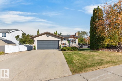 Single-story residence featuring an attached garage, paved driveway, and mature landscaping - 5502 48 Avenue, Beaumont, AB 