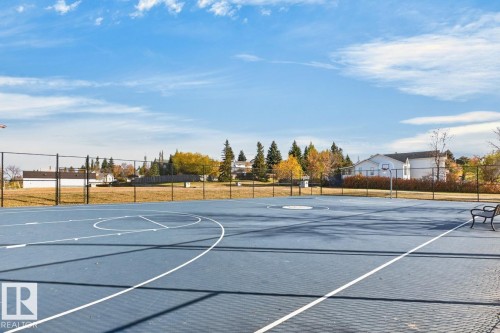 Recreational court featuring a basketball hoop, perimeter fencing, and an integrated bench - 5502 48 Avenue, Beaumont, AB 