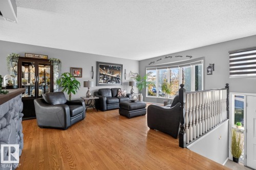 Hardwood flooring, bay window, built-in display cabinet, and staircase with turned balusters - 5502 48 Avenue, Beaumont, AB 
