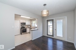 Dark wood-finish flooring with a decorative overhead light fixture - 