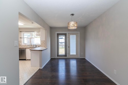 Dark wood-finish flooring with a decorative ceiling fixture - 17311 107 Street Nw, Edmonton, AB 