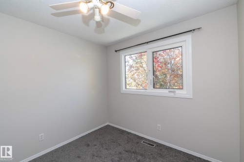 Ceiling fan with integrated lighting, neutral wall paint, white trim, and gray carpet flooring - 17311 107 Street Nw, Edmonton, AB 