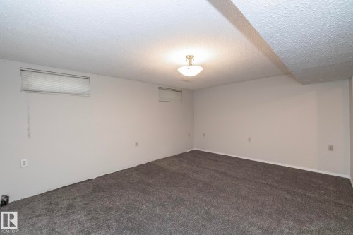 Spacious interior with gray carpeting, white walls, and a semi-flush mount ceiling fixture - 17311 107 Street Nw, Edmonton, AB 