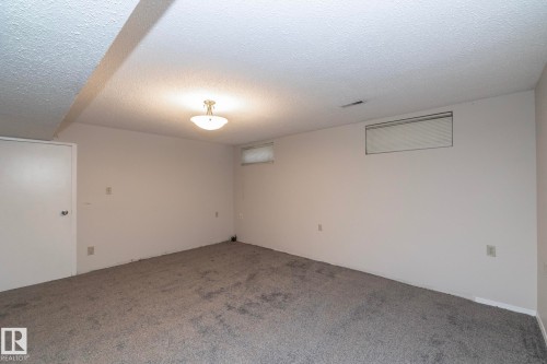 Recessed window, ceiling-mounted light fixture, white interior door, wall-to-wall carpeting, and white wall finishes - 17311 107 Street Nw, Edmonton, AB 