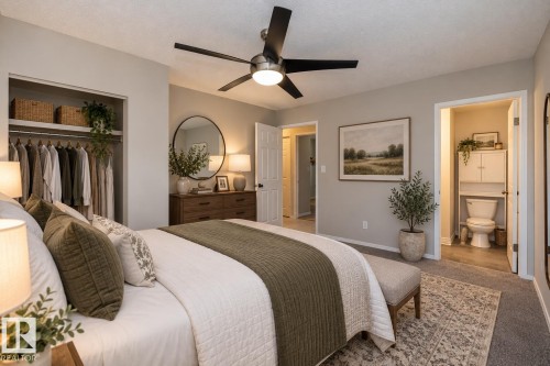 Recessed closet with shelving, ceiling fan with integrated lighting, wood-finish dresser, neutral wall paint, and carpet flooring - 17311 107 Street Nw, Edmonton, AB 