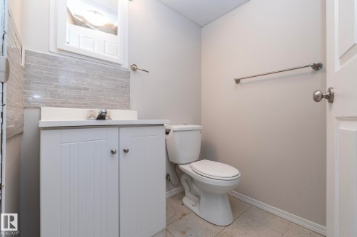 White vanity with dual cabinet doors, integrated sink, and brushed nickel faucet - 17311 107 Street Nw, Edmonton, AB 