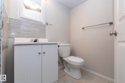 White vanity with dual cabinet doors, integrated sink, and brushed nickel faucet - 