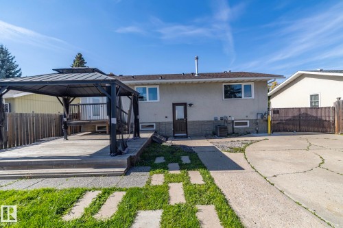 Expansive backyard featuring a multi-level wood deck with a gazebo, a concrete patio, and a grass pathway - 17311 107 Street Nw, Edmonton, AB 