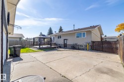 Spacious concrete patio with an elevated wooden deck featuring a gazebo, and a secure fenced perimeter - 