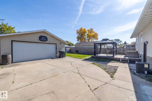 Detached garage with a two-car overhead door, concrete driveway, wood deck with gazebo, and fenced backyard - 17311 107 Street Nw, Edmonton, AB 